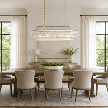 54" Ghiaccio Oval Textured Glass Chandelier with Clear Glass and Brass Finish in a Dining Room