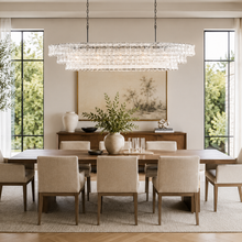 54" Ghiaccio Oval Textured Glass Chandelier with Clear Glass and Bronze Finish in a Dining Room