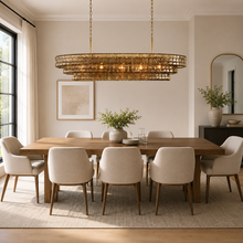 54" Ghiaccio Oval Textured Glass Chandelier with Smoke Glass and Brass Finish in a Dining Room