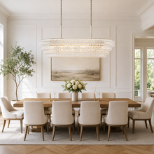 64" Ghiaccio Oval Textured Glass Chandelier with Clear Glass and Brass Finish in a Dining Room