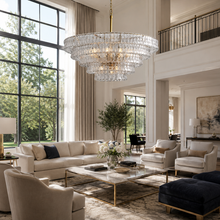 48" Ghiaccio Round Textured Glass Chandelier with Clear Glass and Brass Finish in a Living Room